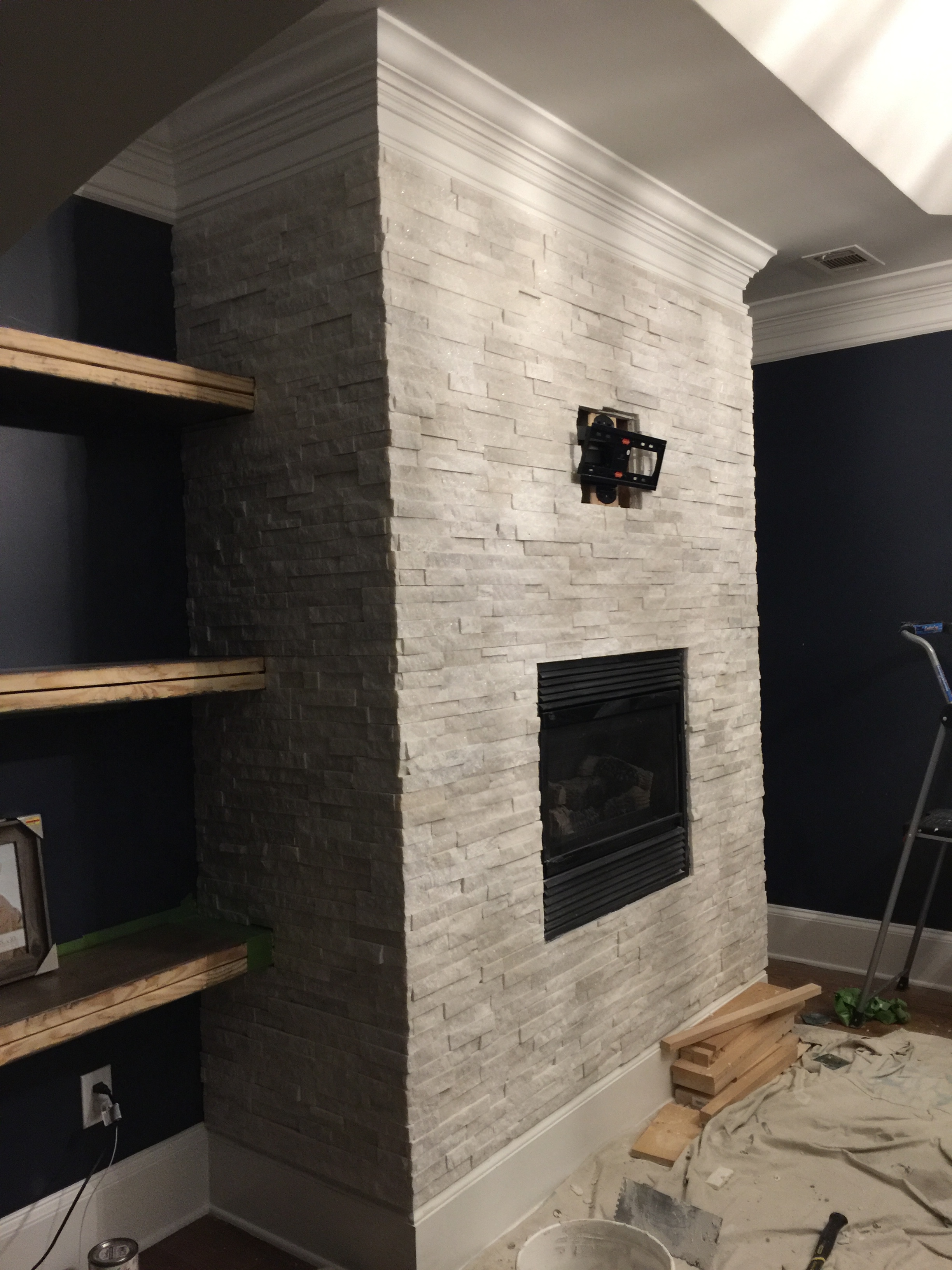 building stone tile fireplace with single shelf